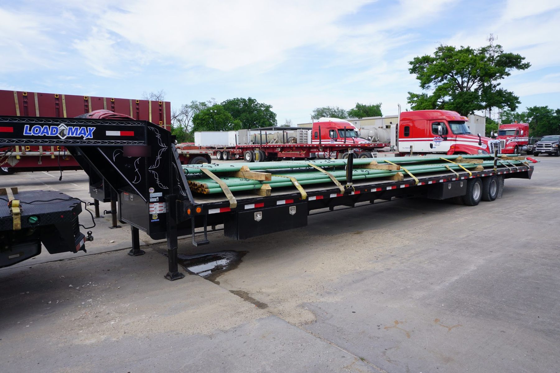 Mini float gooseneck trailer loaded with pipe